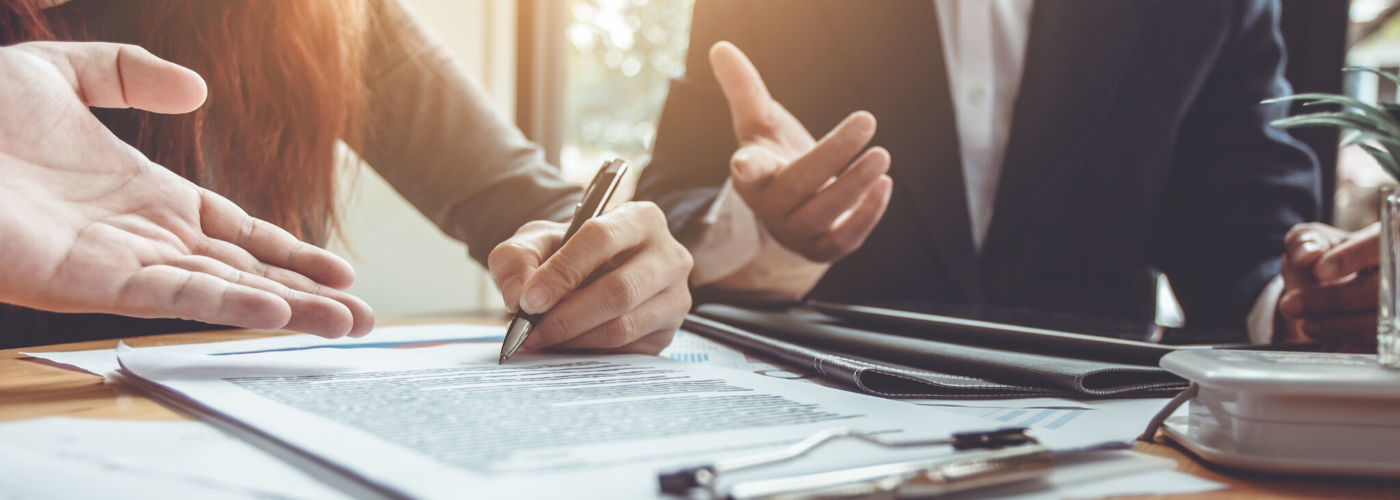 Close-up of two people working at a meeting table