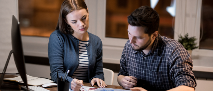 A man and a woman sit at a desk analysing