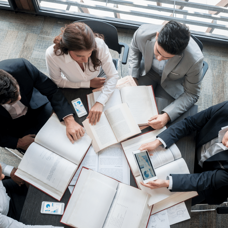 A group of business people around a desk with papers