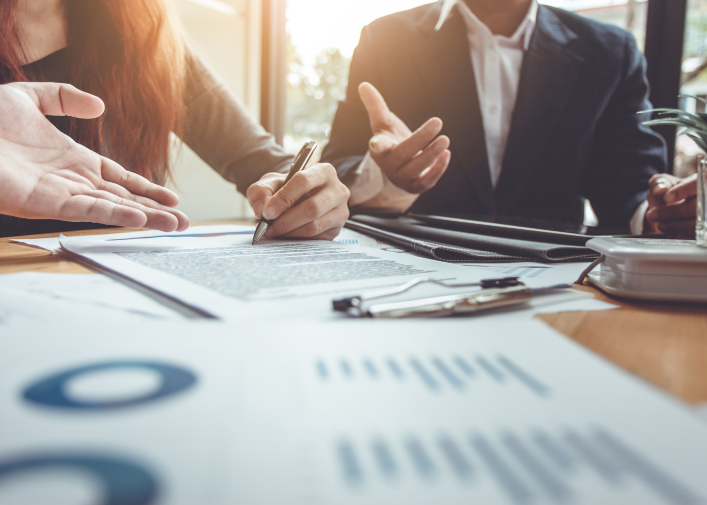 TClose-up of two people working at a meeting table