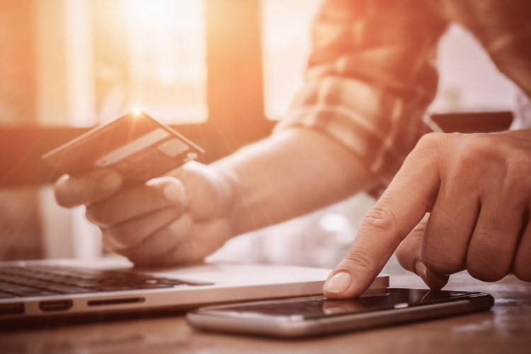 Man hands with a credit card, calculator and laptop.