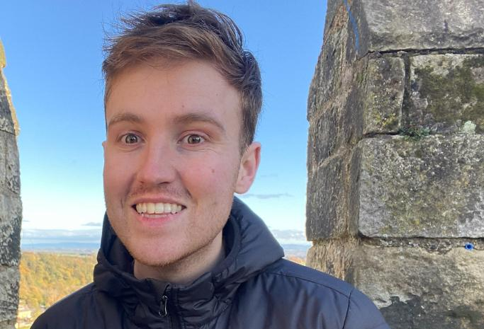 Young man smiling with dark blue jacket on