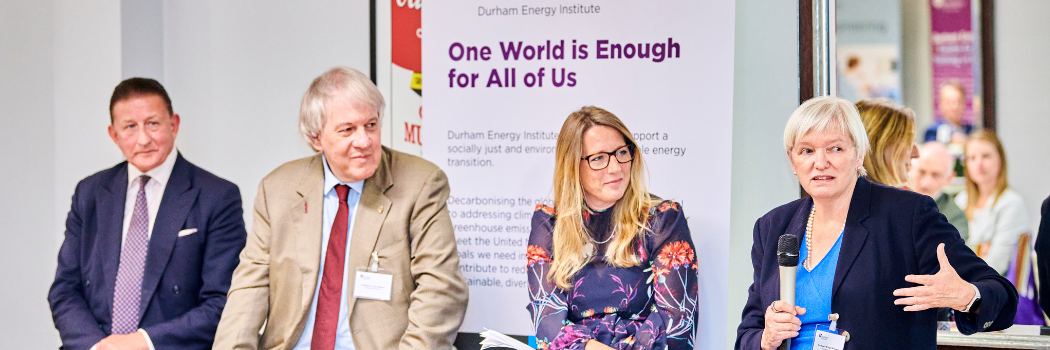 Panel of guests in front of banner