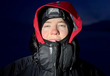 Joe during expedition dressed in snow coat and head torch