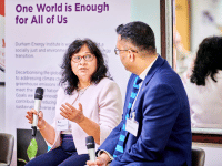 Two researchers chatting with the female holding a microphone