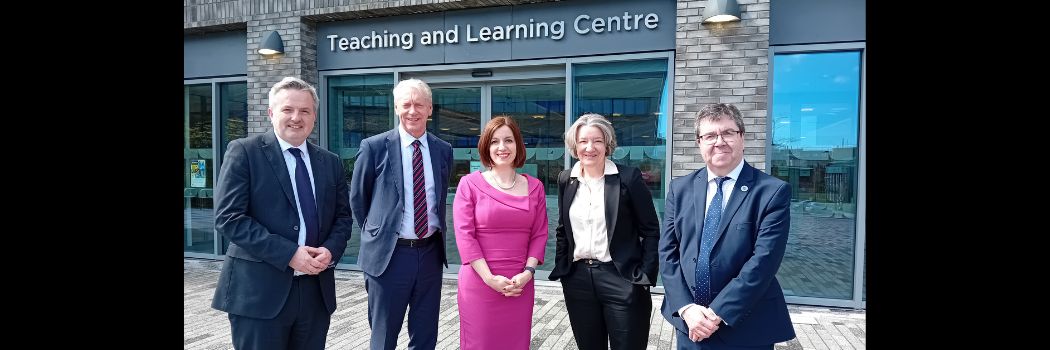 Five people standing outside Teaching and Learning Centre. Bridget Phillpson is centre, with four university leaders