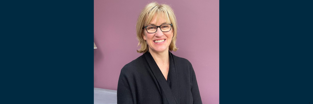 Professor Clare McGlynn smiling to camera, against a light purple background