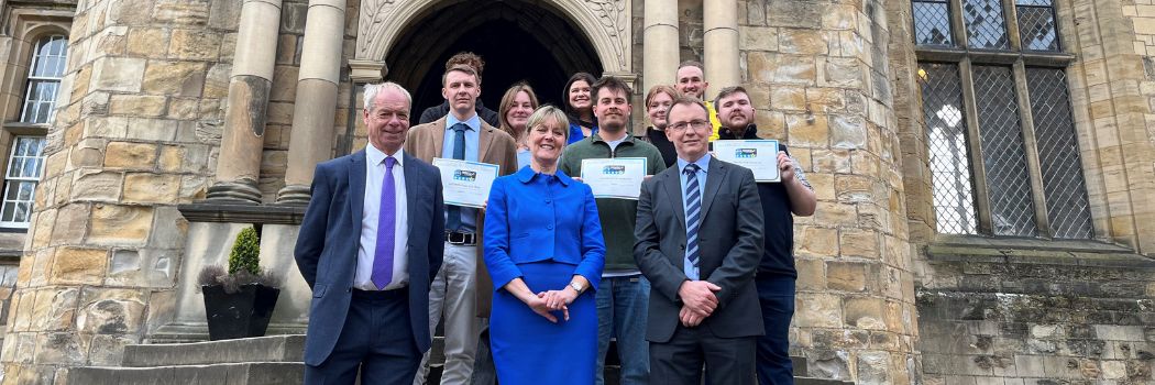 Officials pictured on the steps outside Durham Castle, holding licensing certificates