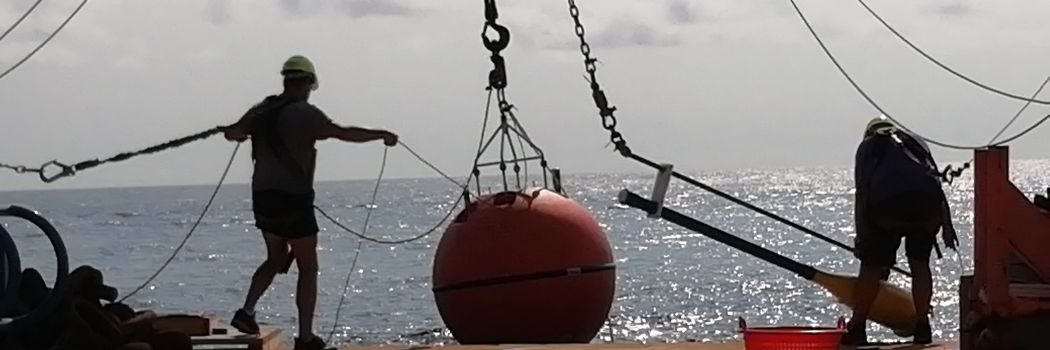 A sensor is lowered from a boat into the ocean