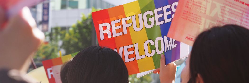 A banner saying refugees welcome at a protest march