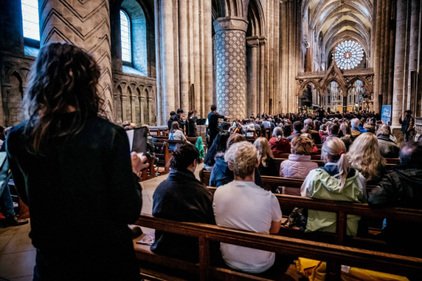 People seated in cathedral watching a performance