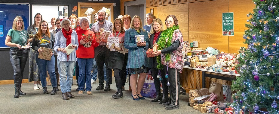 Staff and representatives from the charities posing with Christmas gifts donated to the appeal