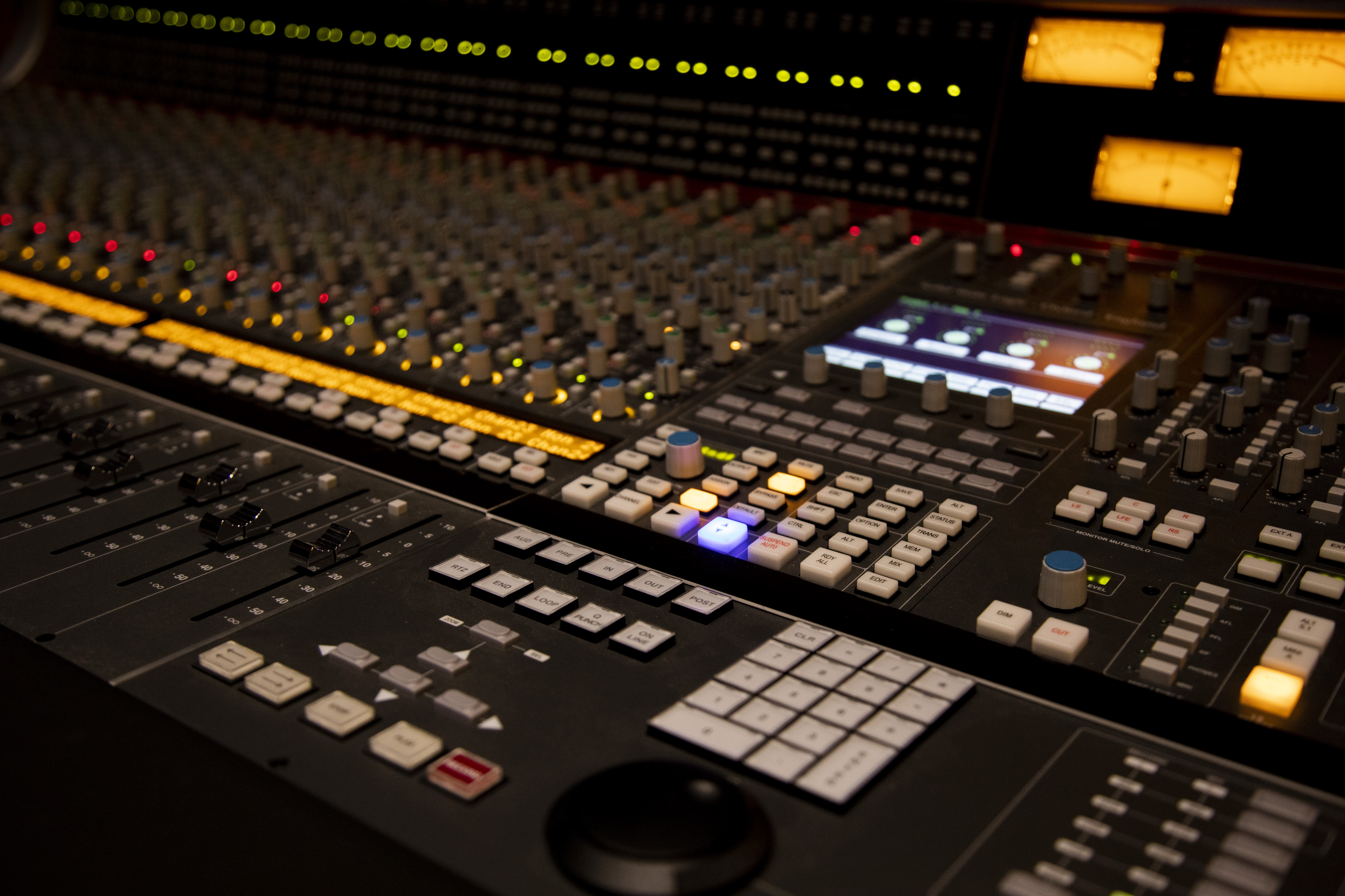 A large music mixing desk with buttons and screens