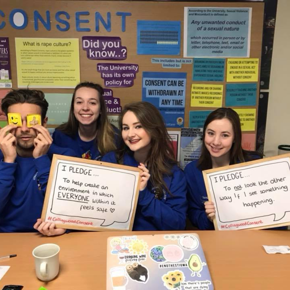 TStudents behind table holding consent campaign posters