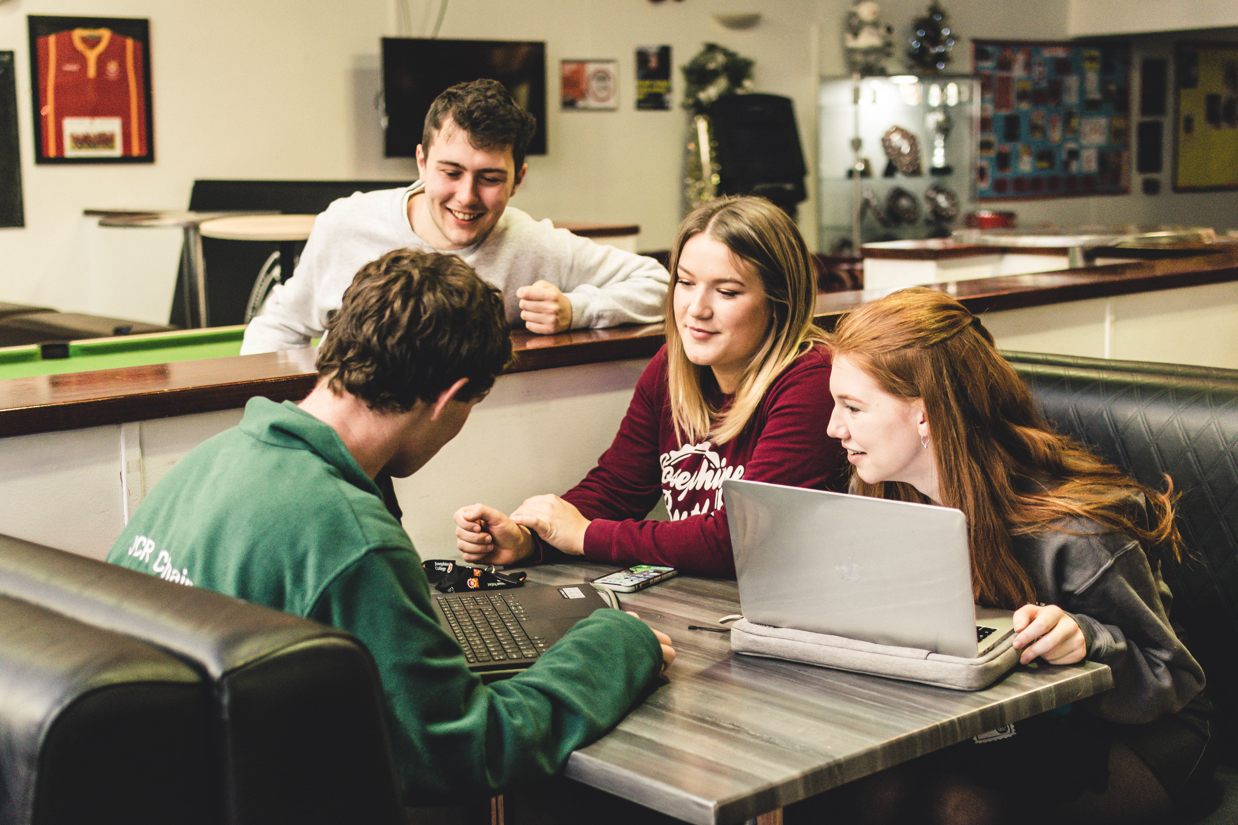 TStudents working in a group on laptops in the common room