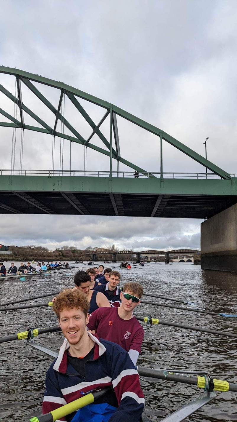 rowers on boat bridge behind