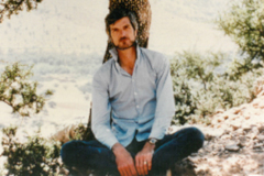 Anthropologist David Brooks sitting against a tree