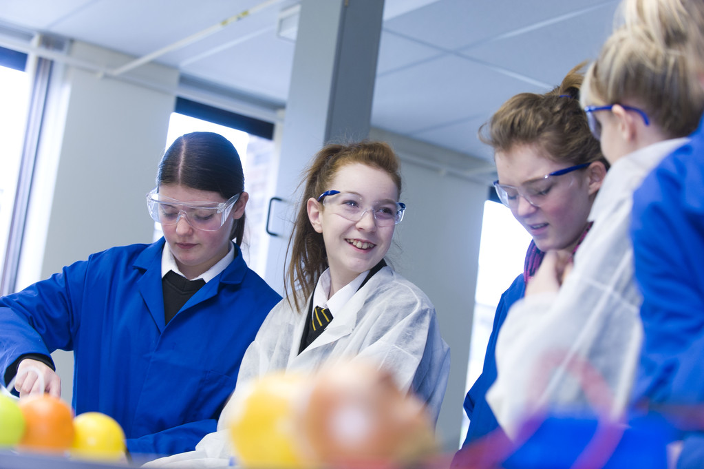 Young students smiling and wearing protective eye equipment