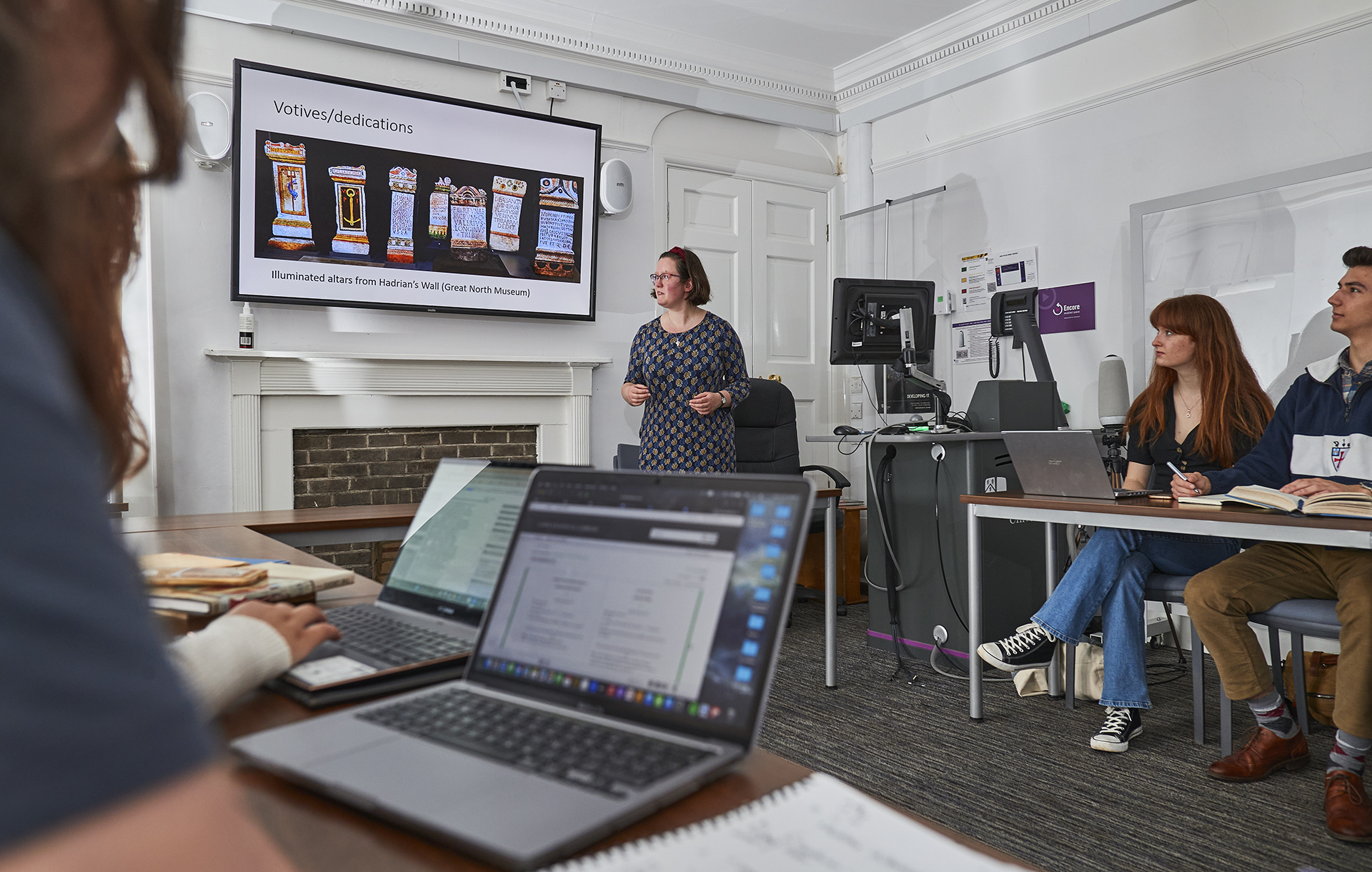 Female professor teaching with laptop in the foreground