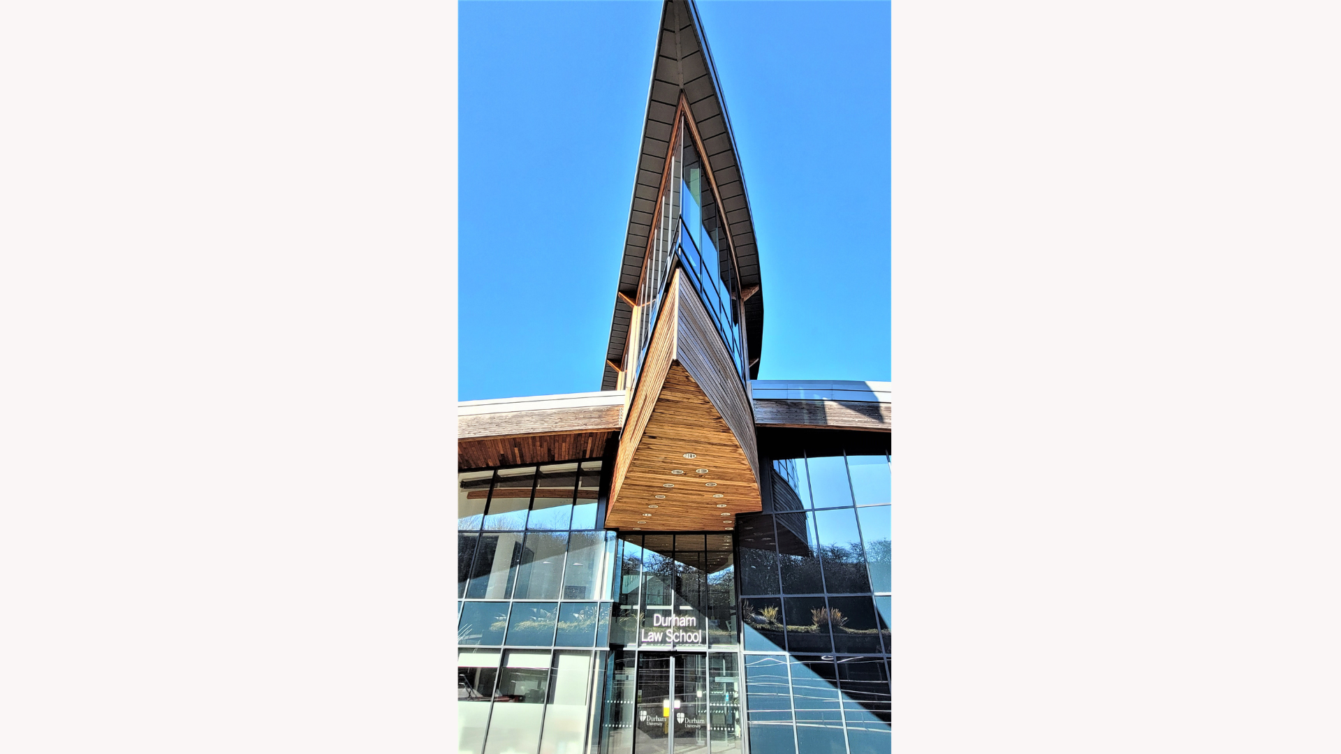 A modern building with a lot of windows, there is a sign that says Durham Law School