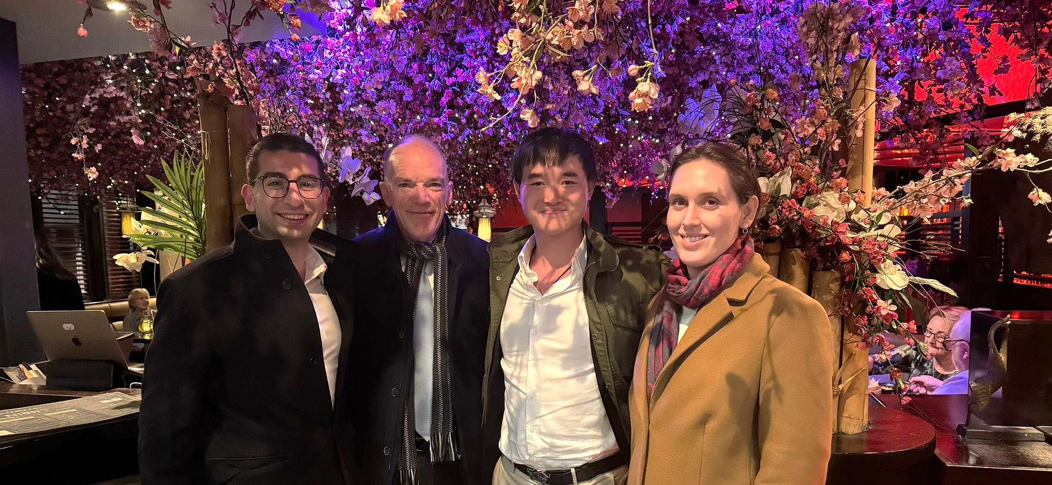 A photo of Can, Volker, Yuk Chi and Elizabeth, underneath a purple tree