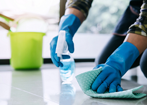 gloved hand cleaning floor