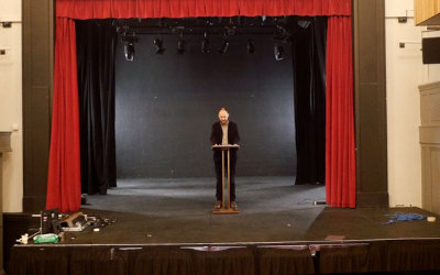 Professor Scholar standing on stage