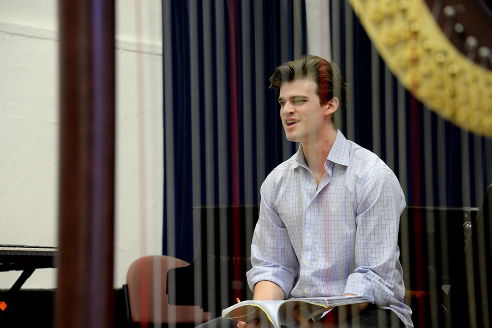 TA person onstage reading a book during a lunchtime concert