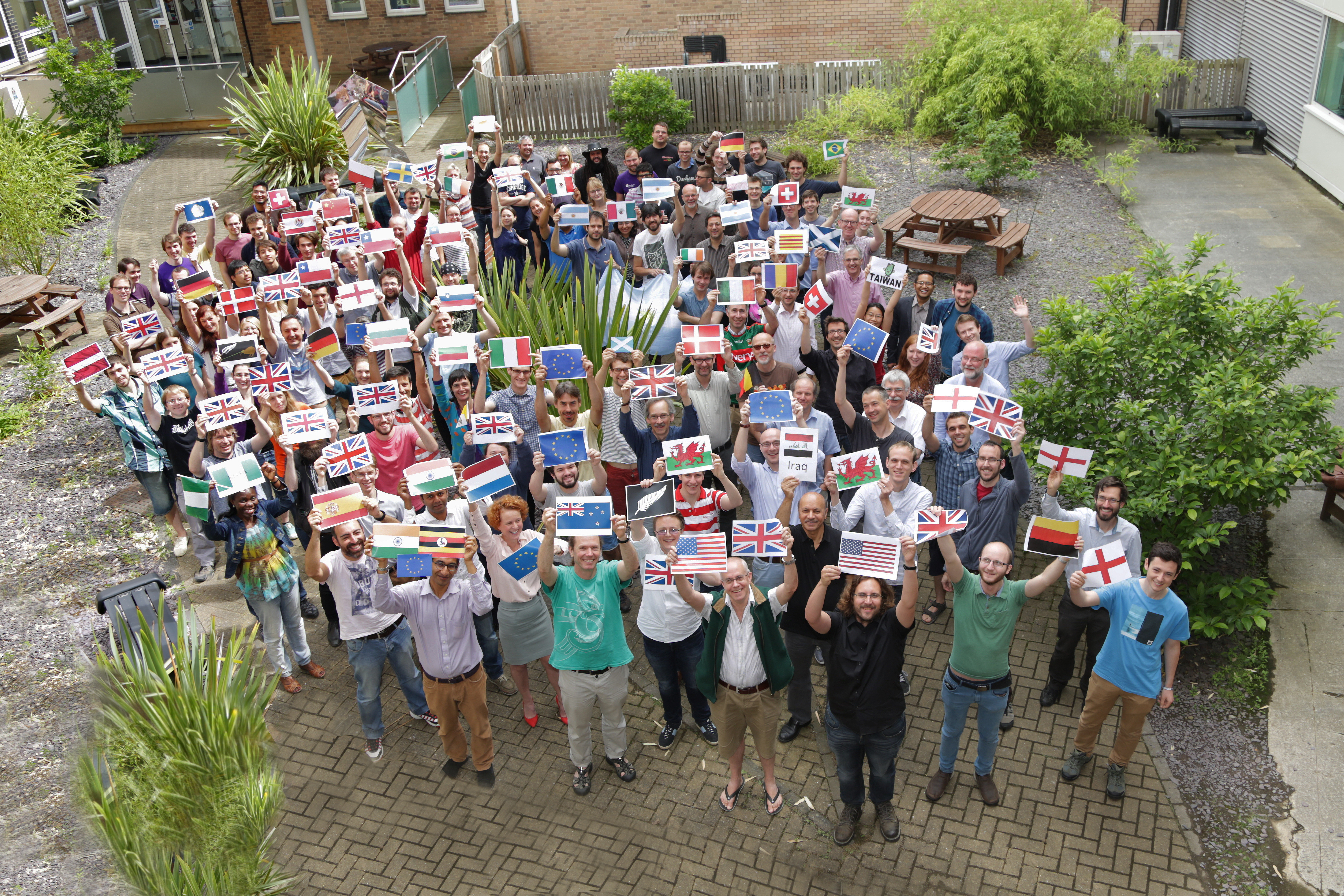 Image showing academic staff, post doctoral and postgraduate students and researchers holding the flags of the countries from where they are from.