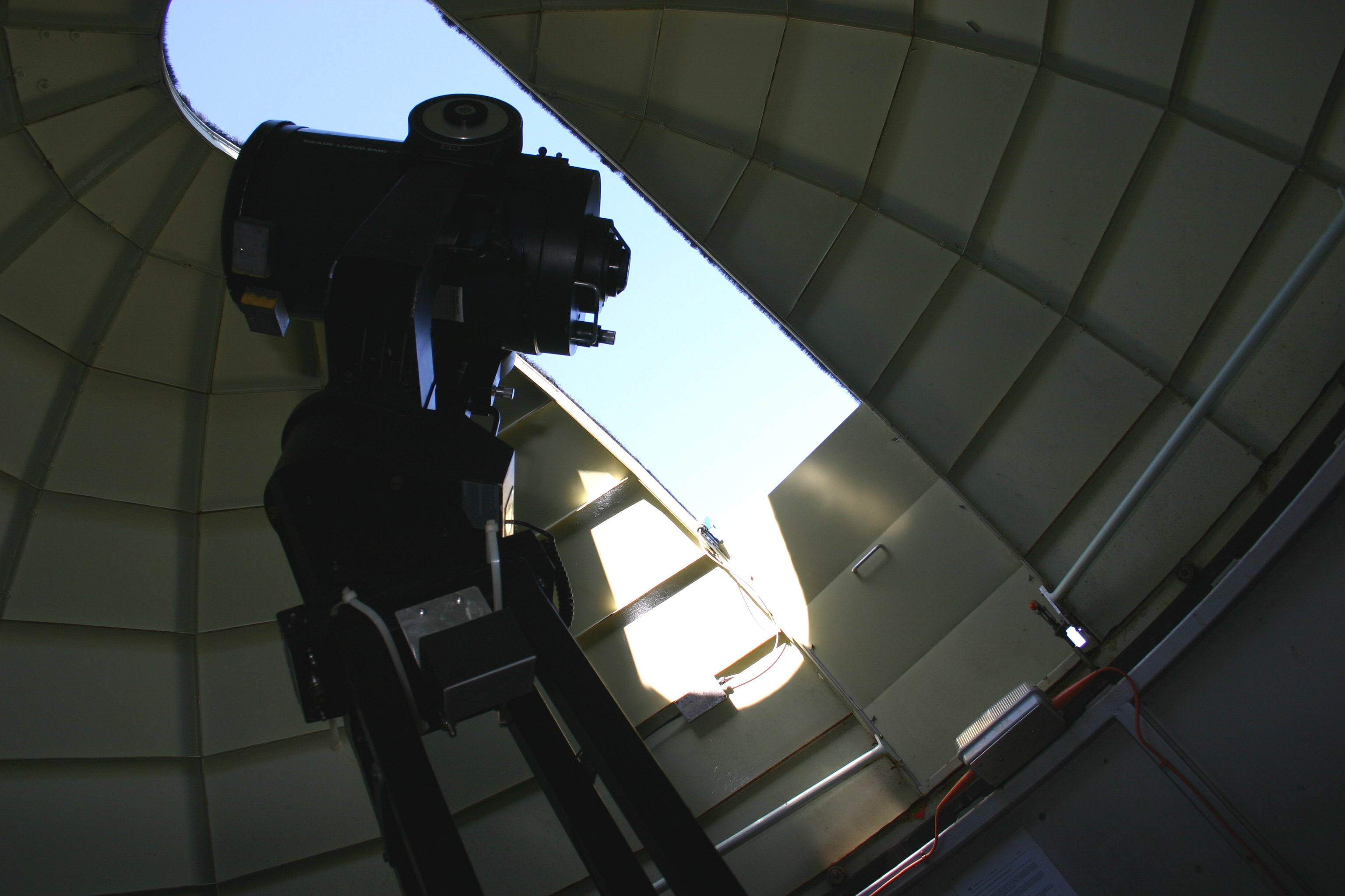 Image of telescope and light entering through opening in dome