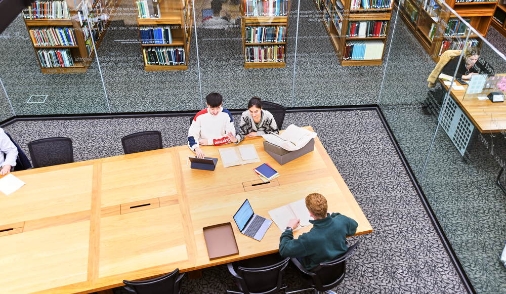 Students are looking at documents in the archives and special collections area within the Barker Research Library