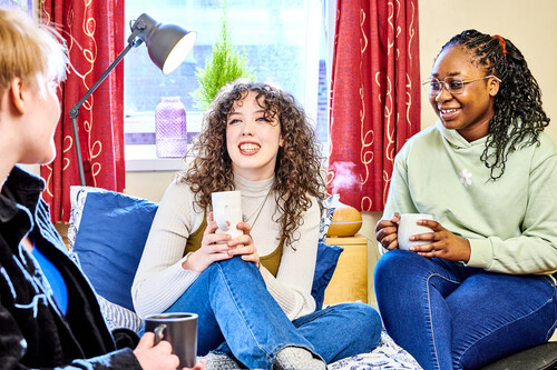 Three students chatting in a University College room