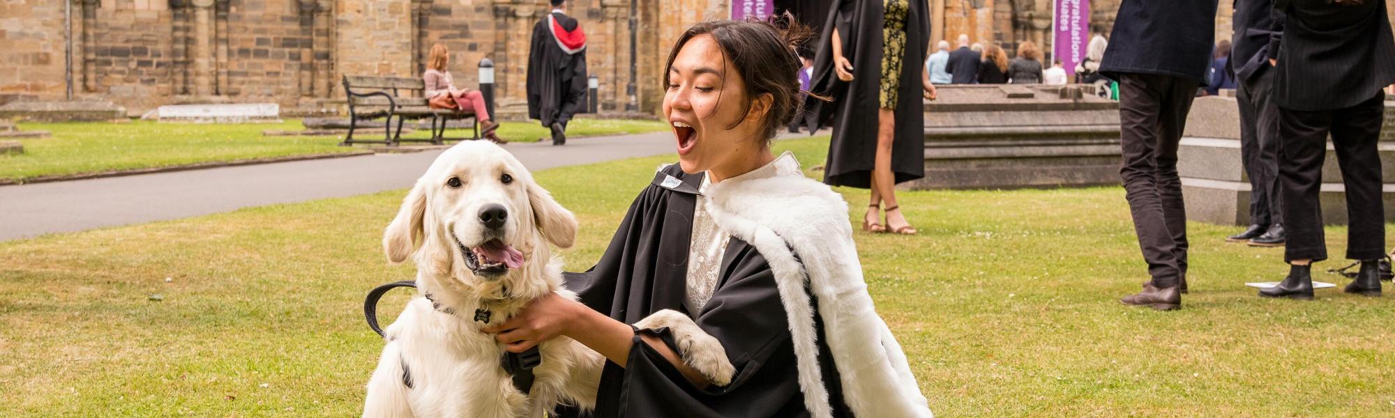 Graduate in robes with dog