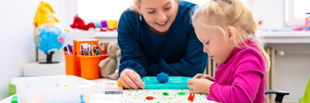 A woman interacting with an infant child using objects