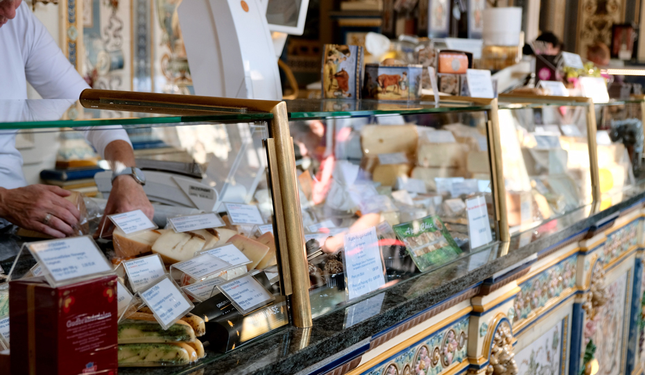 A Dutch delicatessen counter stacked with cheese and smoked meats