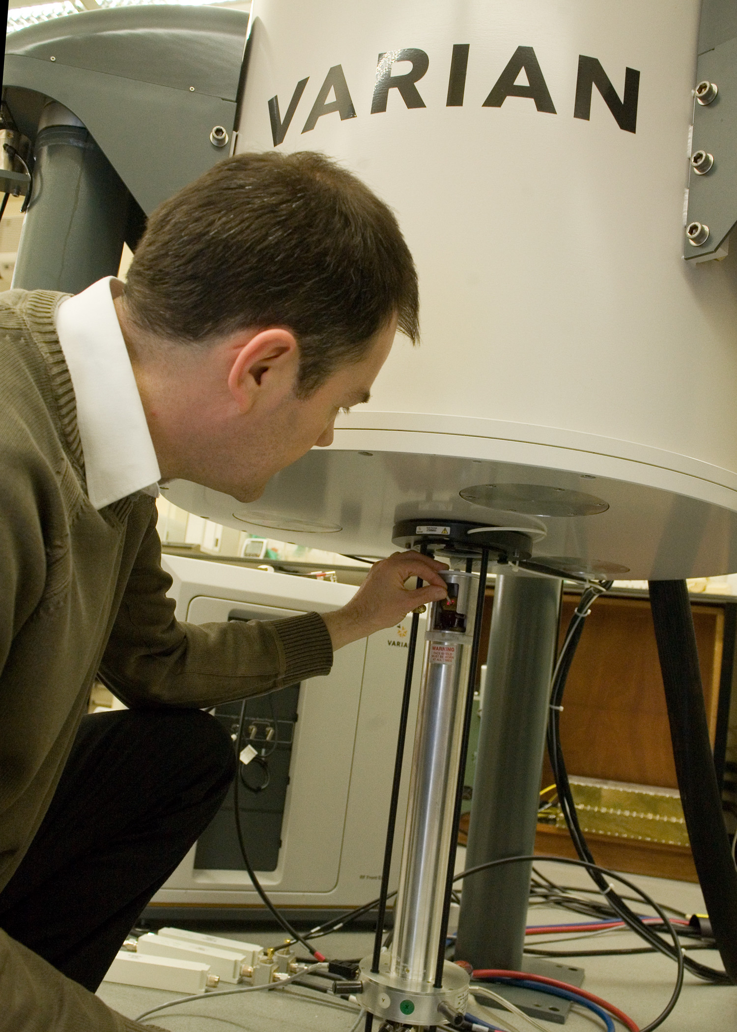 A man using equipment for Solid state nuclear magnetic resonance science