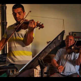 HOPA IIDE film screenshot showing a boy playing a violin