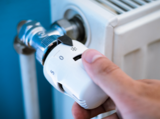 Image of hand turning Heat control knob on Radiator