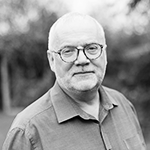 A white man with grey hair, a beard and glasses