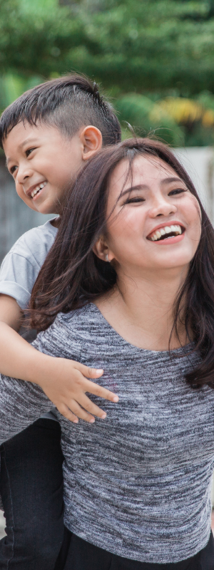 Mother giving child a piggy back