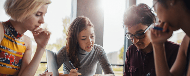 Three female and one male student studying