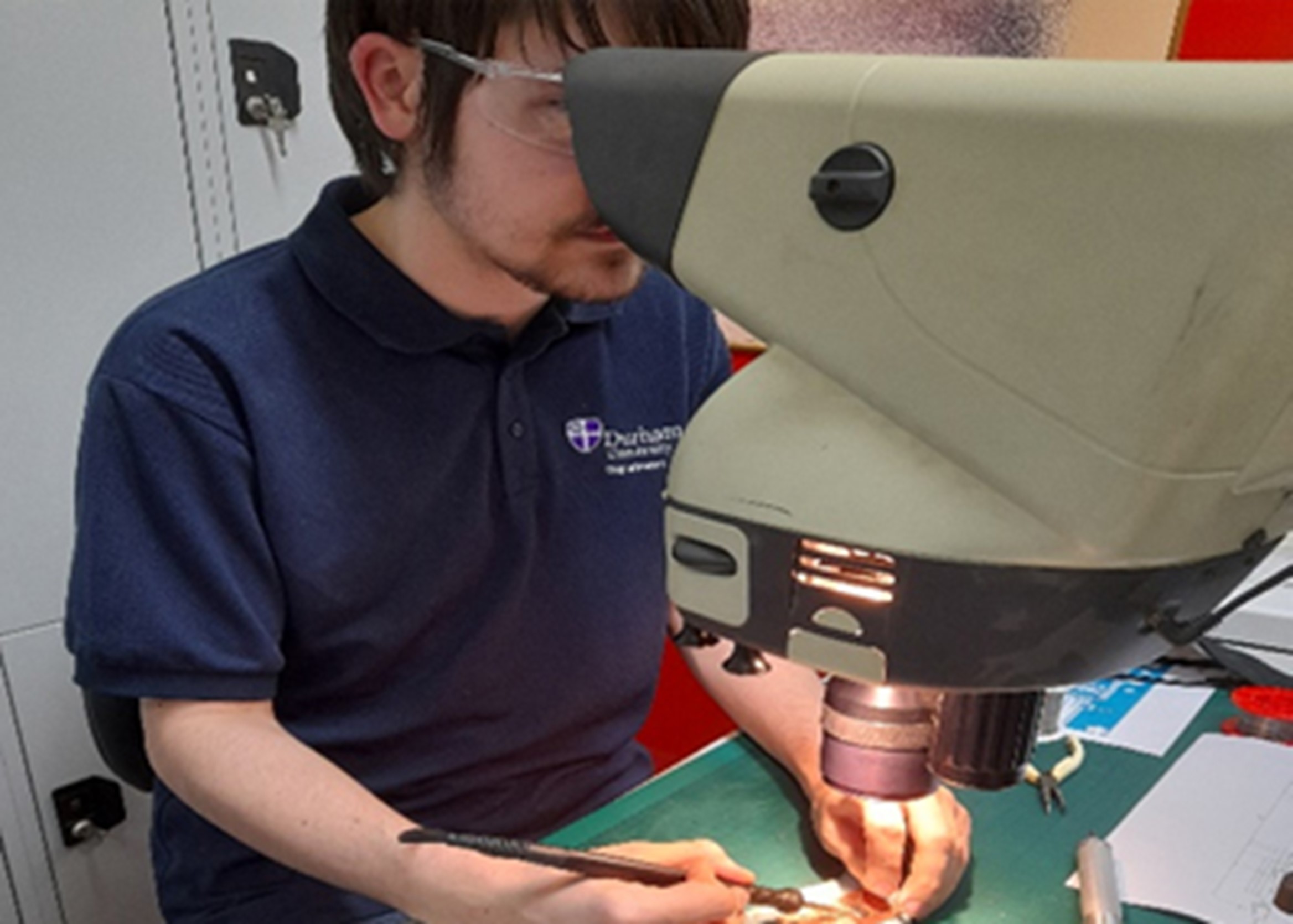 adam easton of technician commitment looking into a piece of equipment