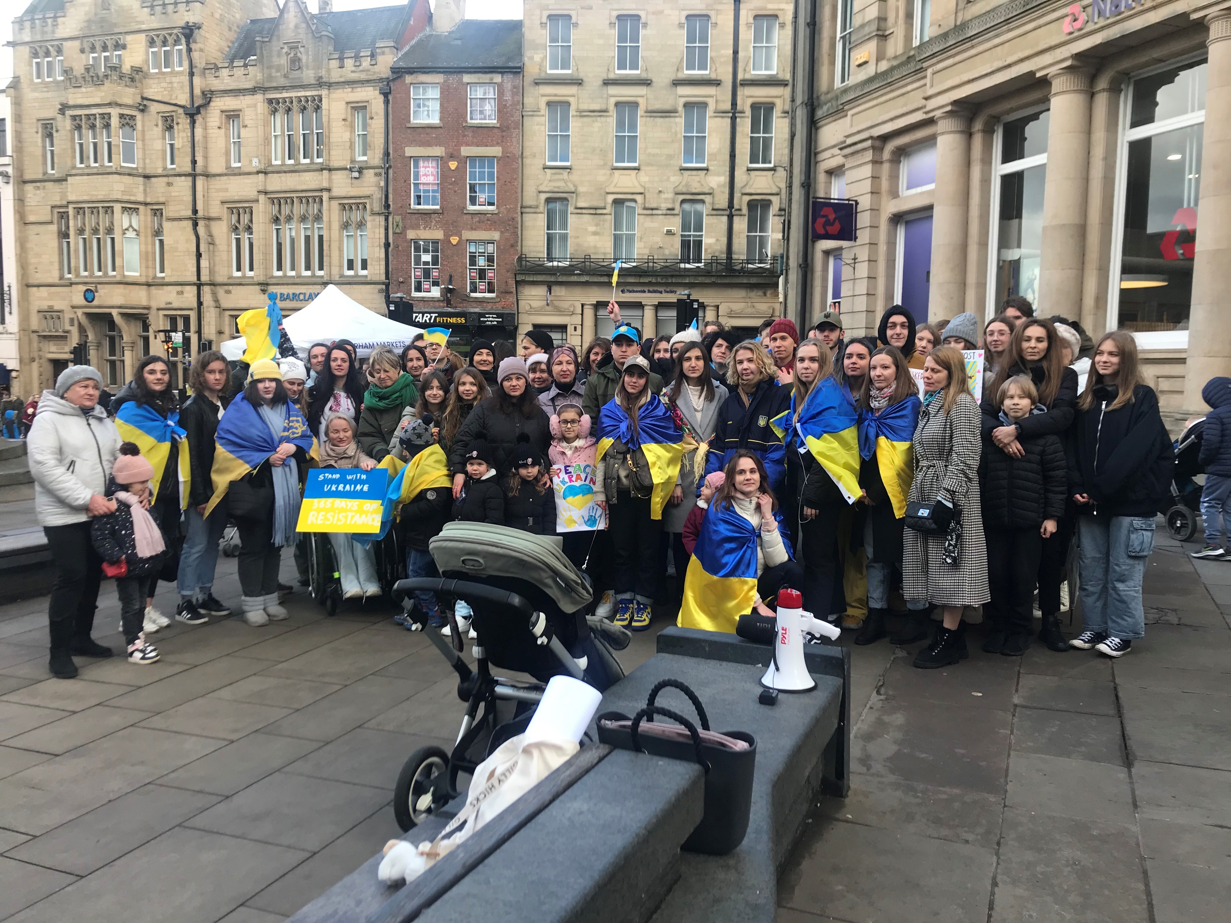 groups of people with Ukraine flags gathered together in a market square