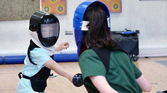 Children training during a holiday camp fencing class