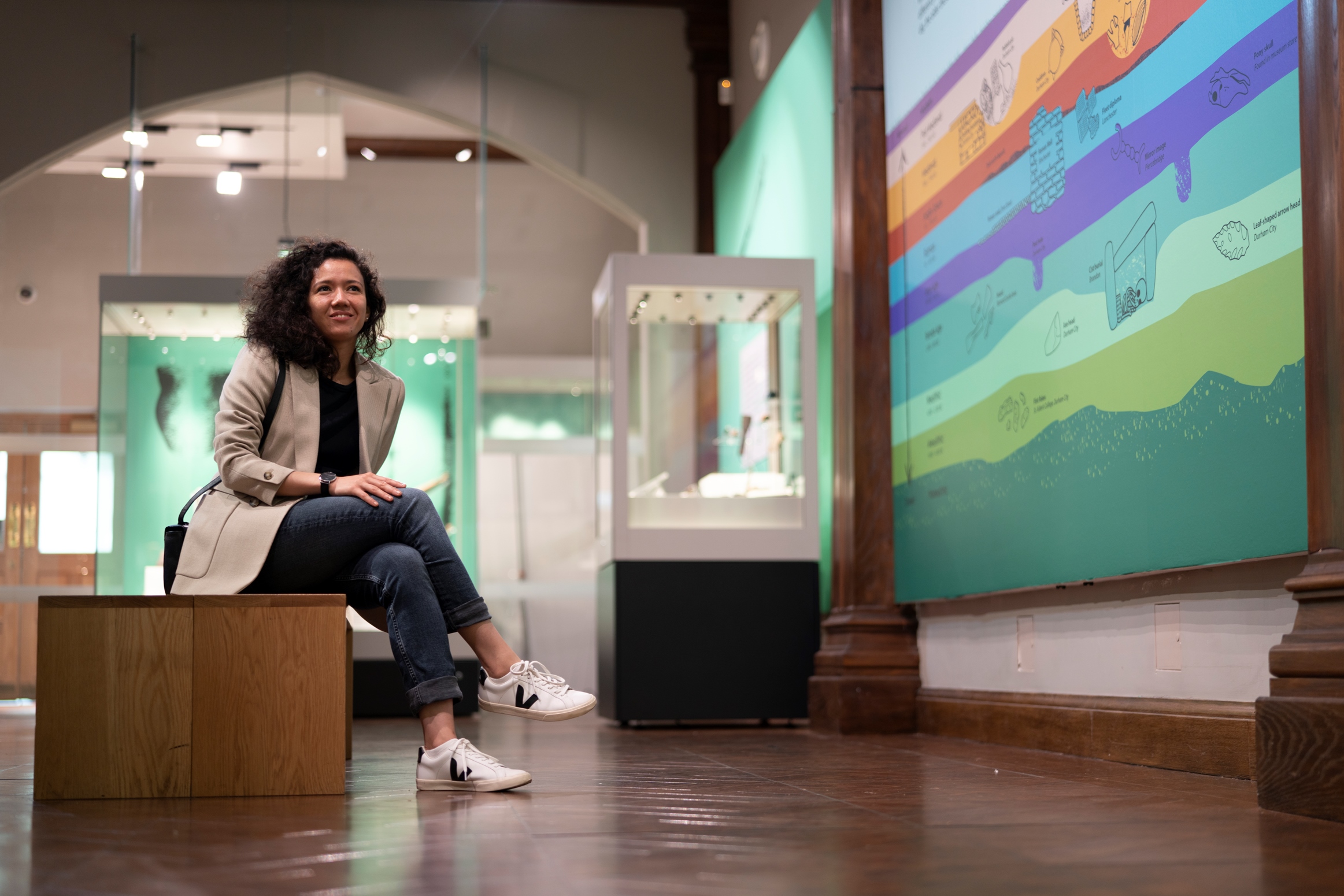 A woman sat in a gallery within the Museum of Archaeology