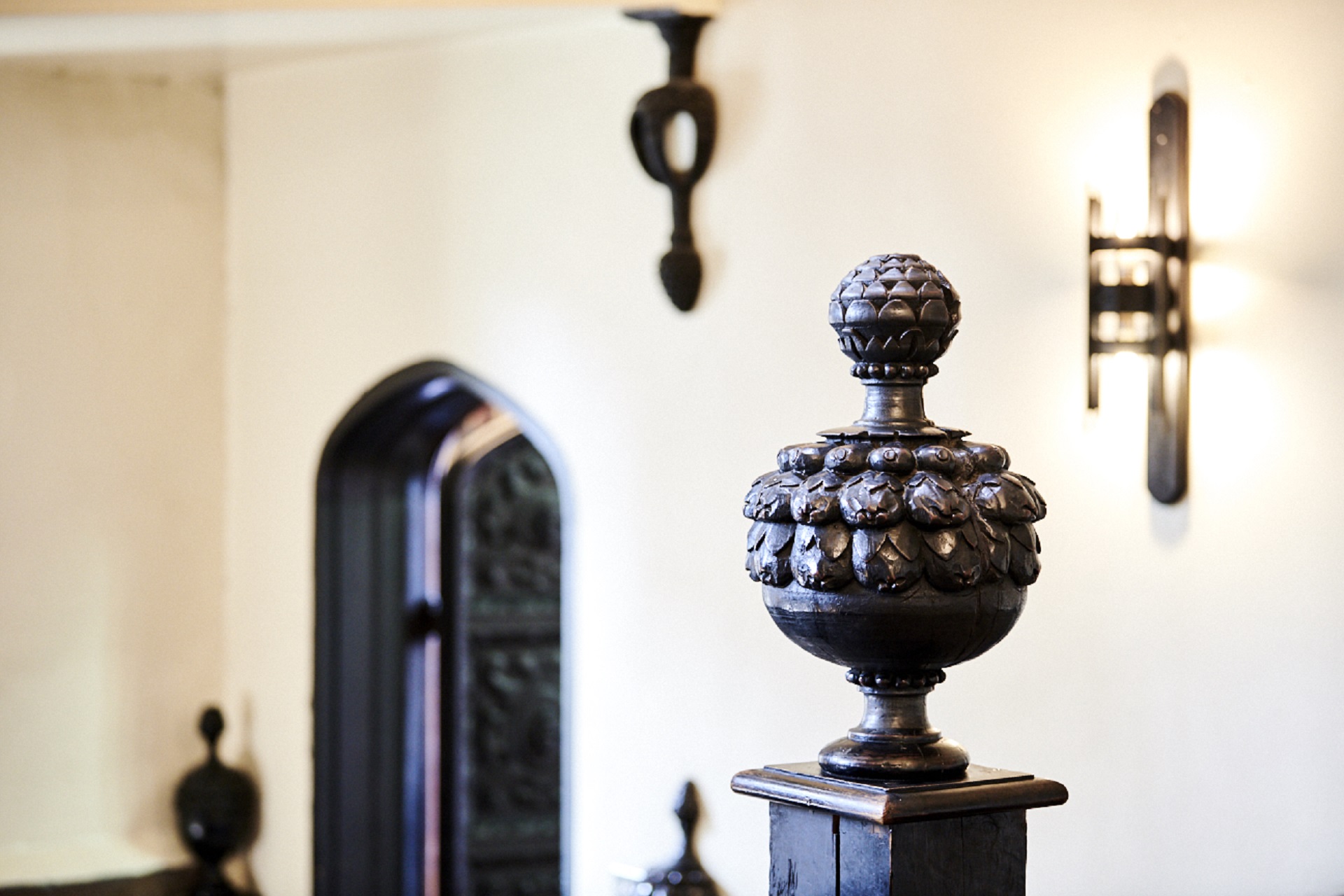 Photograph of the pineapples on the Black Stairs at Durham Castle. On the right is a door and on the left is a carving with is meant to represent a pineapple.