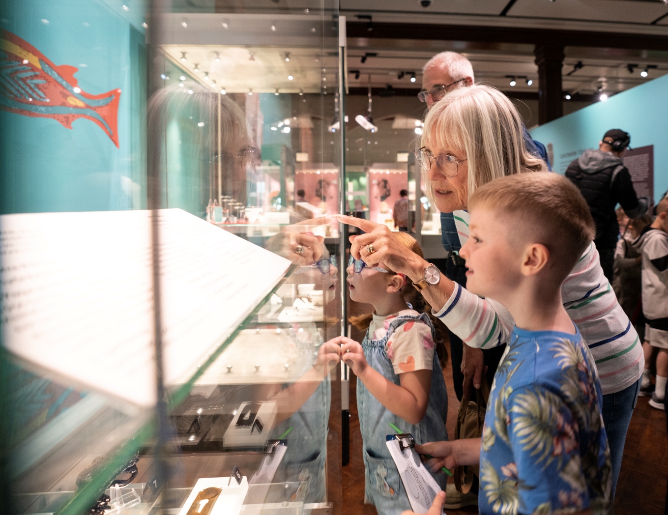 A family examining an exhibit in a gallery within the Museum of Archaeology