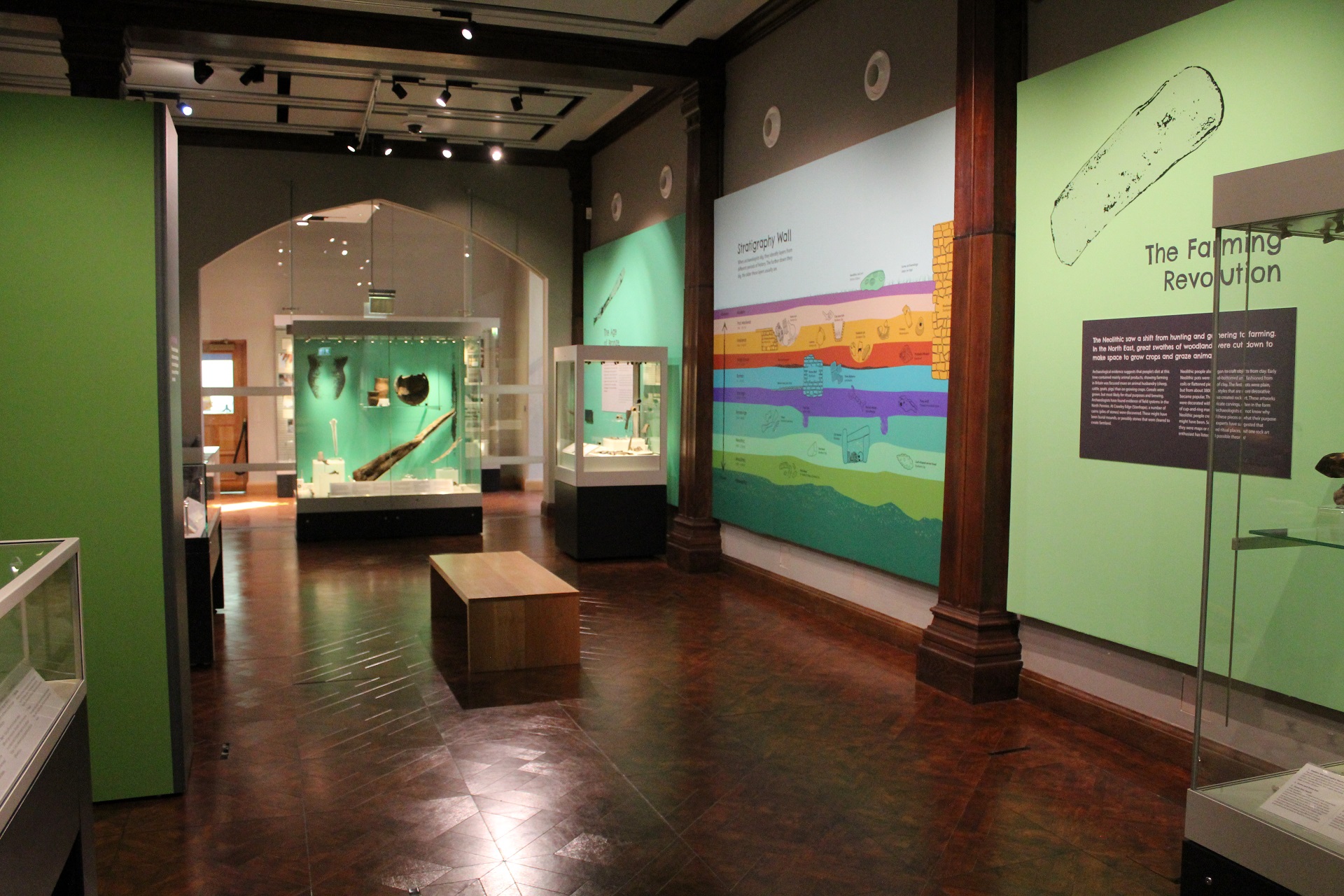 Coloured photograph showing the Prehistory section with its green background in the temporary exhibition at Palace Green Library.